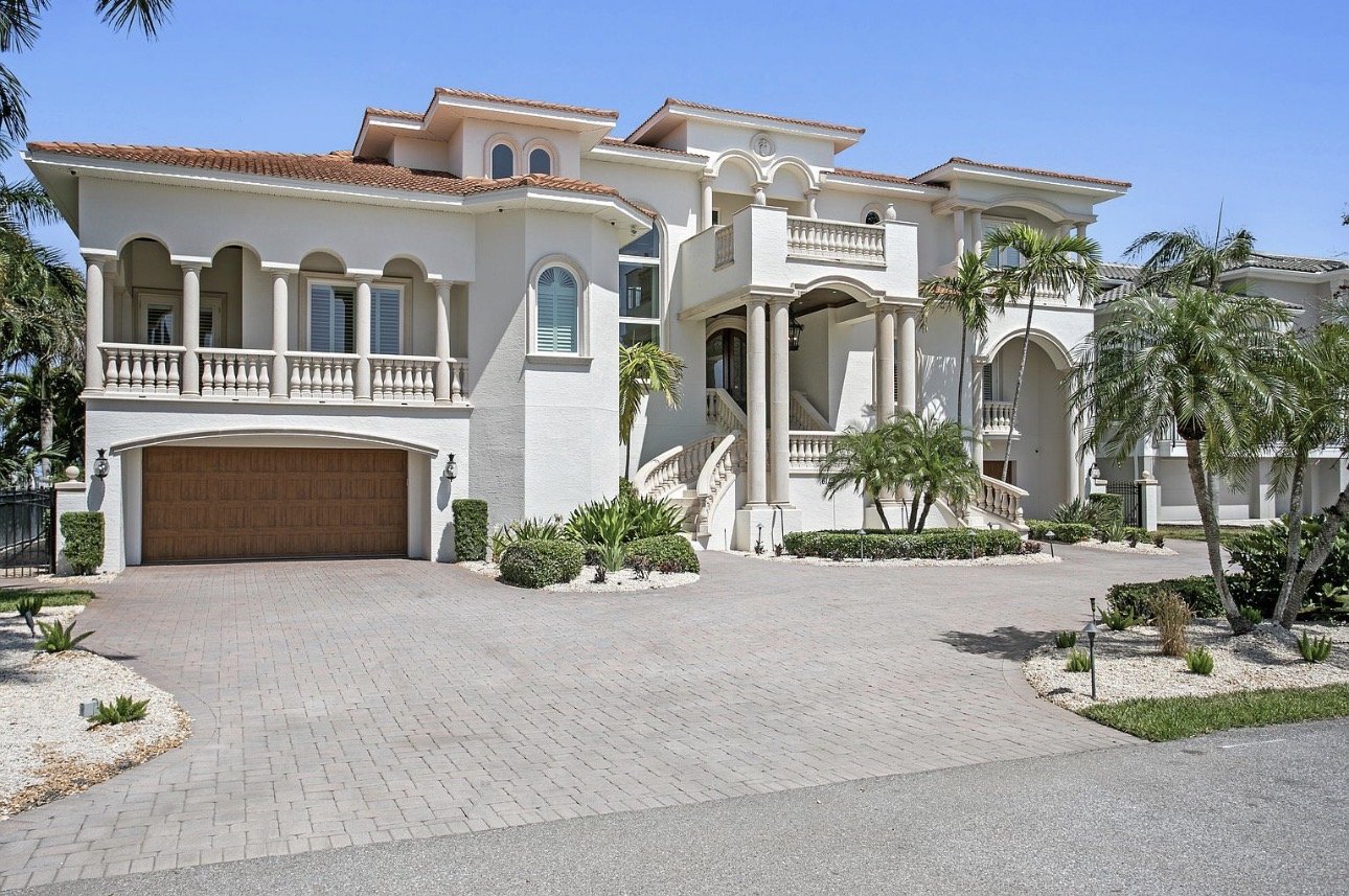 Coastal home with balconies and palm landscaping