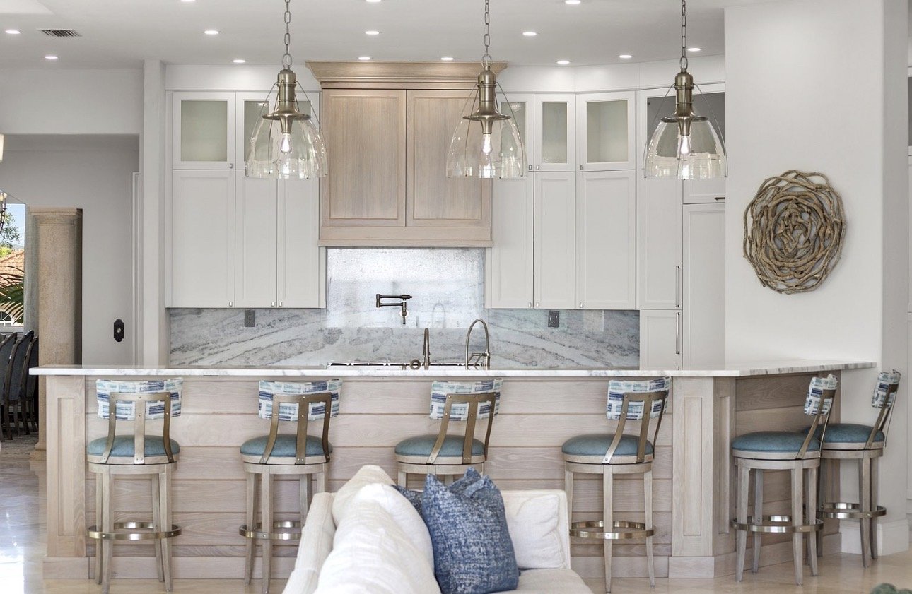 White kitchen with marble island and pendant lights