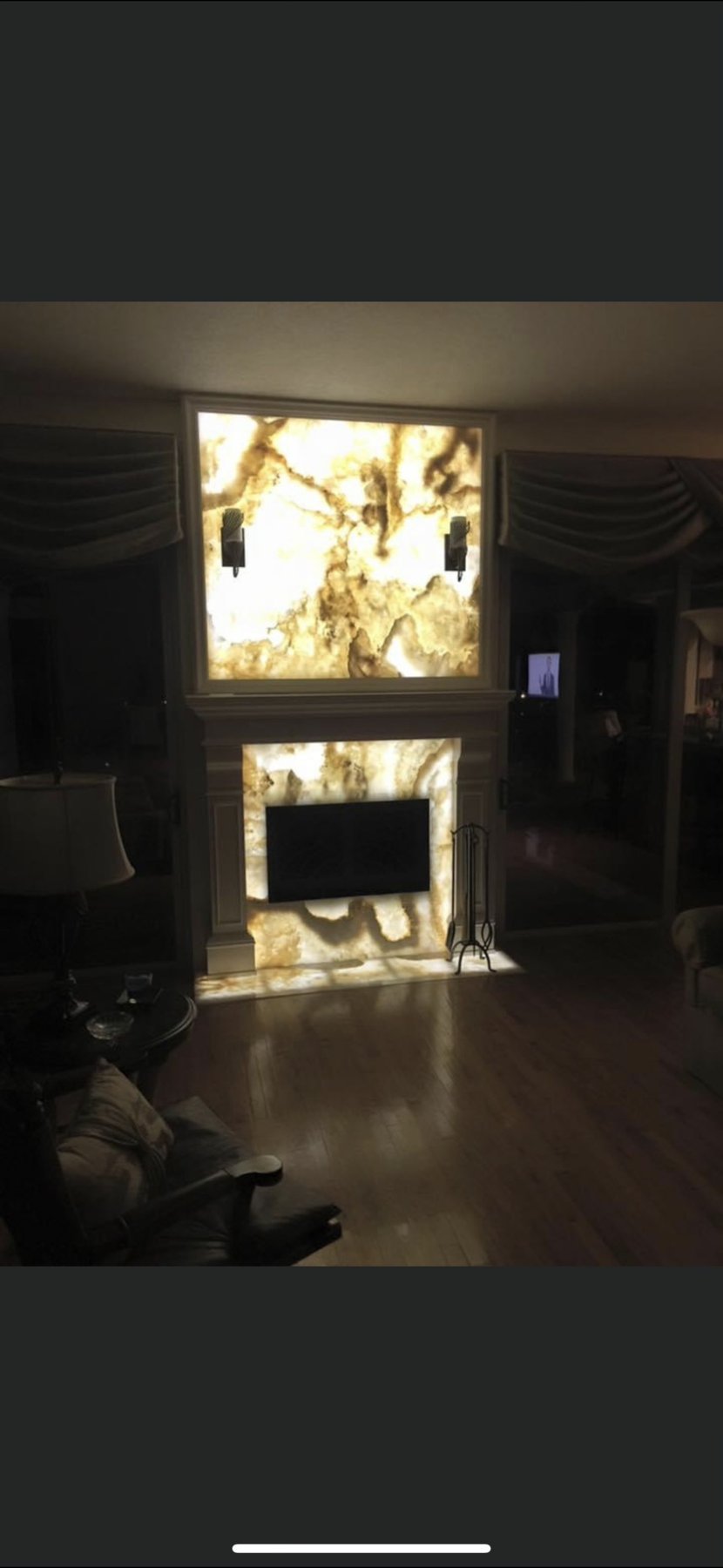 Living room fireplace with backlit stone surround
