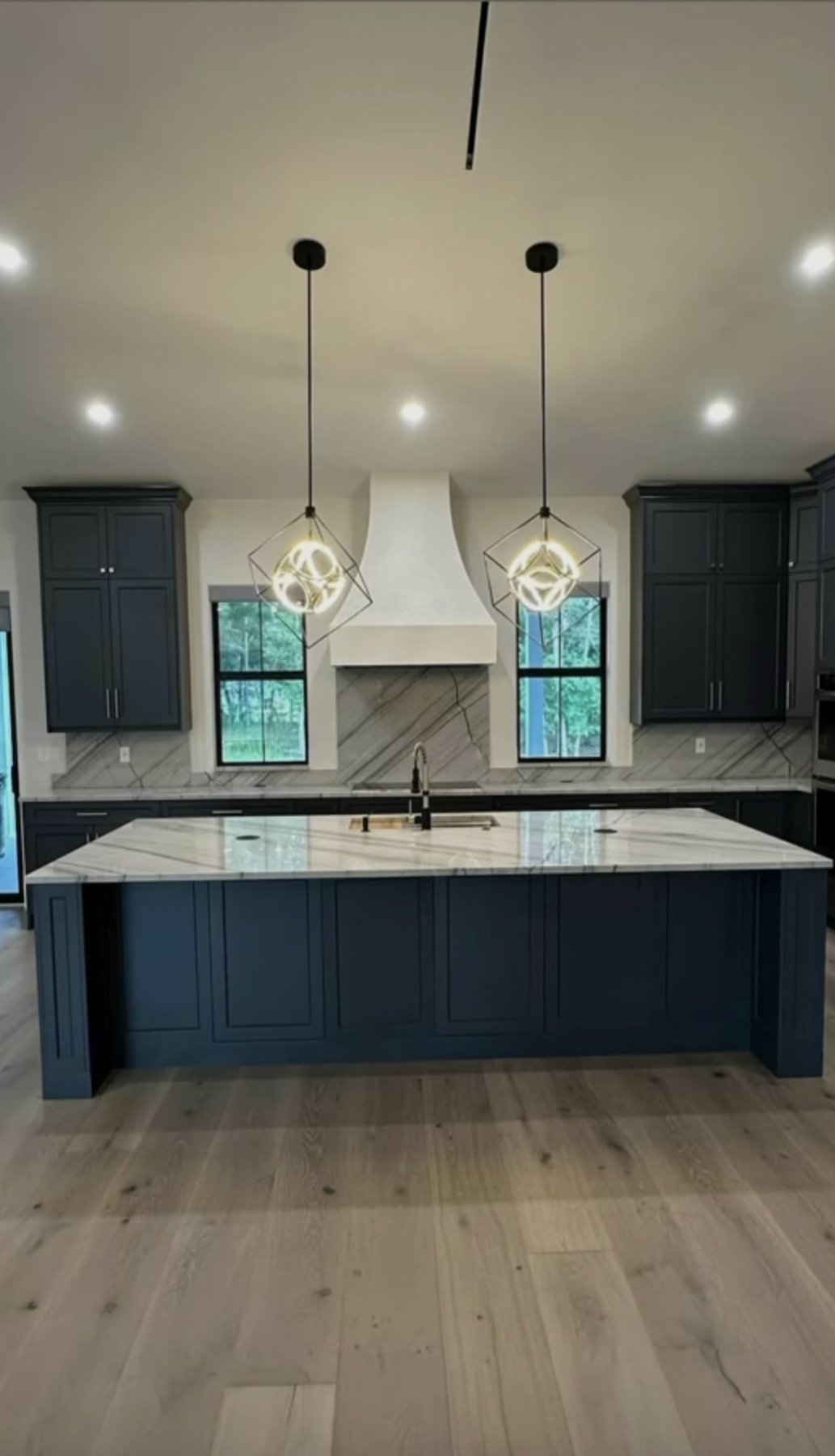 Bathroom vanity with pendant lights and dark cabinets