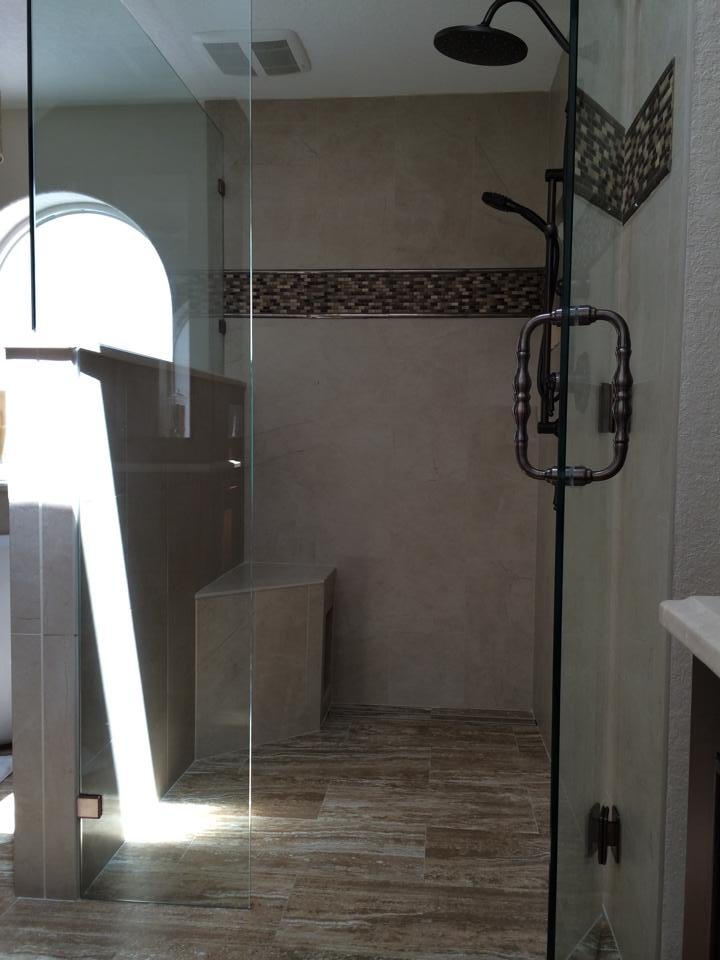 Walk-in shower with arched window and mosaic floor